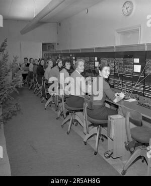 Telefonie in den 1950er. Frauen, die in einer Telefonzentrale arbeiten, als Telefonisten. Ein manuell betriebenes Telefonkommunikationssystem, bei dem die eingehenden Anrufe vom Betreiber weitergeleitet und an eine andere Telefonnummer umgeleitet wurden, in diesem Fall lokal innerhalb des Gebäudes, das ein Unternehmen oder eine Organisation mit vielen internen Telefonleitungen bedient. Die Telefonzentrale konnte Nachrichten entgegennehmen und Sie in die Warteschleife setzen, wenn die Leitung besetzt war. Schweden 1953. Kristoffersson Ref. 68K-21 Stockfoto