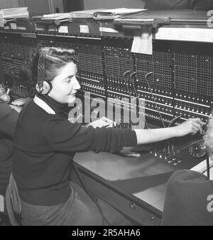 Telefonie in den 1950er. Frauen, die in einer Telefonzentrale arbeiten, als Telefonisten. Ein manuell betriebenes Telefonkommunikationssystem, bei dem die eingehenden Anrufe vom Betreiber weitergeleitet und an eine andere Telefonnummer umgeleitet wurden, in diesem Fall lokal innerhalb des Gebäudes, das ein Unternehmen oder eine Organisation mit vielen internen Telefonleitungen bedient. Die Telefonzentrale konnte Nachrichten entgegennehmen und Sie in die Warteschleife setzen, wenn die Leitung besetzt war. Schweden 1953. Kristoffersson Ref. BM70-9 Stockfoto