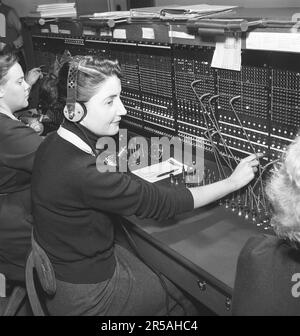 Telefonie in den 1950er. Frauen, die in einer Telefonzentrale arbeiten, als Telefonisten. Ein manuell betriebenes Telefonkommunikationssystem, bei dem die eingehenden Anrufe vom Betreiber weitergeleitet und an eine andere Telefonnummer umgeleitet wurden, in diesem Fall lokal innerhalb des Gebäudes, das ein Unternehmen oder eine Organisation mit vielen internen Telefonleitungen bedient. Die Telefonzentrale konnte Nachrichten entgegennehmen und Sie in die Warteschleife setzen, wenn die Leitung besetzt war. Schweden 1953. Kristoffersson Ref. BM70-10 Stockfoto