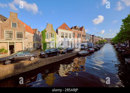 HAARLEM, NIEDERLANDE - 24. MAI 2022: Klare Reflexionen von Häusern am Kanal des Burgwal an einem sonnigen Abend. Stockfoto