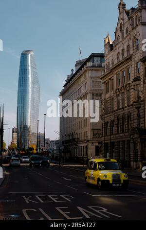 London, Vereinigtes Königreich - 14. Mai 2022. Gelbes Londoner Taxi auf der New Bridge Street mit einem Blackfriars Wolkenkratzer im Hintergrund. Stockfoto