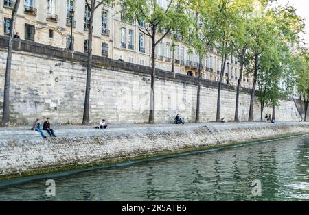 Paris, Frankreich - 09-12-2018: Junge Menschen sitzen am Ufer der seine Stockfoto