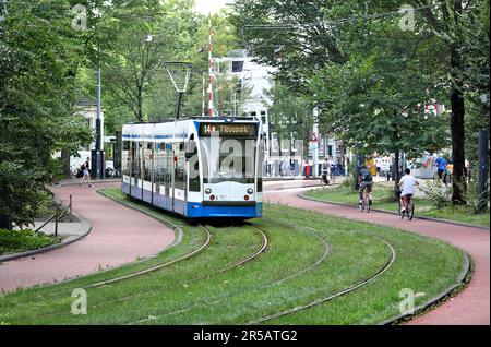 Eine Straßenbahn schlängelt sich durch Plantage Middenlaan, einen grünen Verkehrskorridor (Straßenbahnlinien, Radwege und Fußwege) im Wertheimpark, Amsterdam. Stockfoto