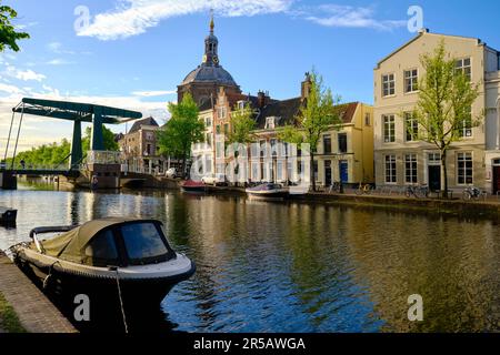 Leiden, Niederlande, 09. Mai 2022. Das Boot liegt auf dem Kanal Oude Vest mit Brücke und Kirche im Hintergrund. Stockfoto