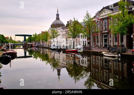 Leiden, Niederlande, 09. Mai 2022. Der Kanal Oude Vest, traditionelle Häuser und die protestantische Kirche Marekerk. Klare Reflexionen. Stockfoto