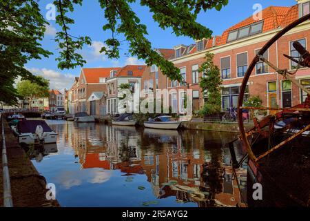 HAARLEM, NIEDERLANDE - 24. MAI 2022: Klare Reflexionen von Häusern am Kanal des Burgwal an einem sonnigen Abend. Stockfoto