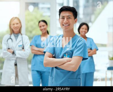 Porträt, Medizin und ein asiatischer Mann Krankenschwester die Arme gekreuzt, stand mit seinem Team in einem Krankenhaus für Gesundheitswesen. Führung, Medizin und Teamarbeit mit einem Stockfoto
