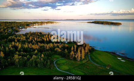 Eine malerische Landschaft mit einem ruhigen See, umgeben von üppigen grünen Bäumen und sanften Hügeln Stockfoto