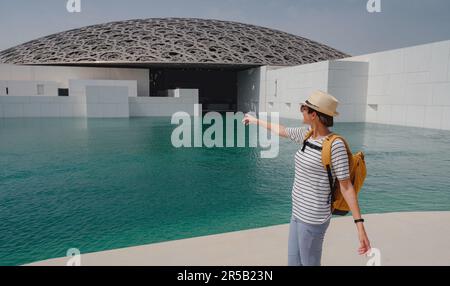 Abu Dhabi, Vereinigte Arabische Emirate - 21. März 2023 : weibliche Reisende in der Nähe des Louvre in Abu Dhabi, Vereinigte Arabische Emirate. Der Louvre ist ein neues Museum in den Vereinigten Arabischen Emiraten, das am 8. 2017. November eröffnet wurde Stockfoto