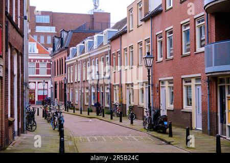 Utrecht, Niederlande - März 16 2022: Eine leere Seitenstraße im Stadtzentrum mit Fahrrädern, die auf dem Bürgersteig geparkt sind. Stockfoto