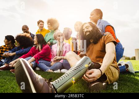 Multiethnische Gruppe, die Spaß in einem öffentlichen Park hat - ein Amputee-Mann hängt mit seinen Freunden im Freien ab - Freundschaft- und Diversitätskonzept Stockfoto