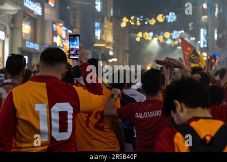 Eine Gruppe von Fans mit den Galatasaray-Shirts, die den Rücken gekehrt haben, feiern die Galatasaray-Meisterschaft in Istanbul, die Fans feiern Stockfoto