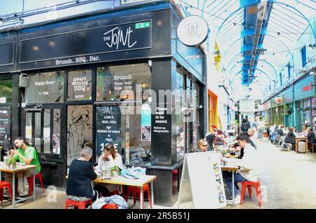 Der Joint; brixton SW9 Markt mit Verkaufsständen, Läden, Restaurants, Bars usw. in der Arkade und an der Straße in lambeth london england, Großbritannien; brixton Village Market Row und brixton Village Stockfoto