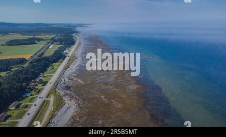 Luftaufnahme eines weitläufigen Strandes mit kristallblauen Wellen, die sich in Richtung der Küste Rollen Stockfoto