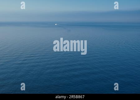 Ganz allein ein weißes Boot im blauen Meer Stockfoto