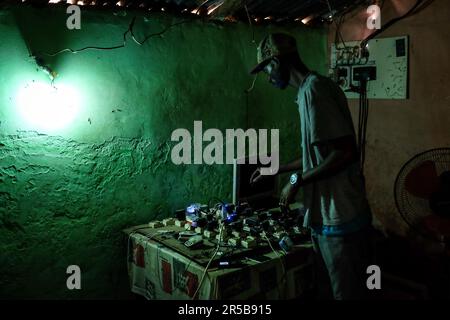 Nicolas Remene / Le Pictorium - Solarenergie und ländliche Entwicklung in der Region Gabu - 13/03/2017 - Guinea-Bissau / Gabu / Gabu - Pirada, Computer- und Elektronikreparaturwerkstatt von Sacko Balde. Außerdem werden Mobiltelefone aufgeladen. *Solar Home System (SHS): Solar Home Energy System. Stockfoto