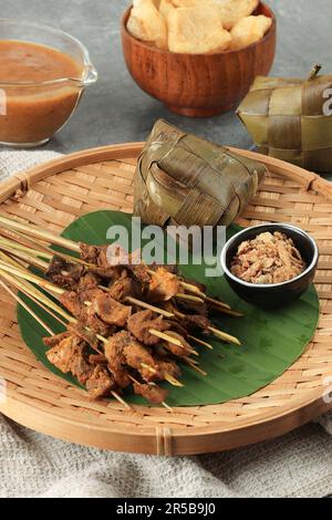 Sate Padang, indonesische Küche, Padang-Rind und Darm-Satay mit würziger, dicker Sauce. Serviert mit Katupat Reiskuchen Stockfoto