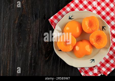 Draufsicht Dosenpfirsiche in Süßsirup, Kopierraum auf Holztisch Stockfoto