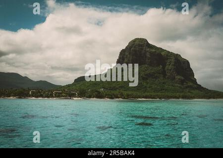 Zwei Segelboote auf einem ruhigen Ozean, gleiten vor einer majestätischen Bergkulisse mit üppigem Grün Stockfoto