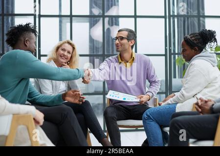 Geschäftsleute sitzen mit Dokumenten auf der Bühne und reden im Hub Stockfoto