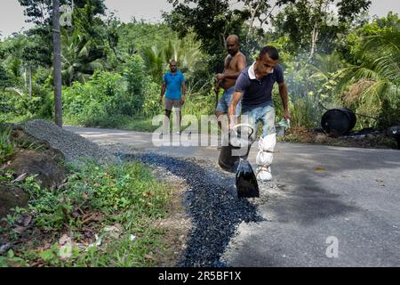 Die Bauarbeiter gießen frischen Asphalt auf eine Straße Stockfoto
