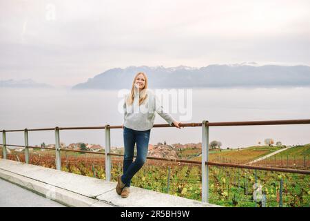 Außenporträt einer wunderschönen jungen Frau, die im Spätherbst oder Frühling im Kanton Vaud in der Schweiz die Region Lavaux besucht Stockfoto