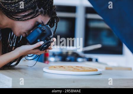 Mit Engagement und Professionalität fotografiert eine Frau eine Flittchen für ihren Blog, trotz geringer Bezahlung Stockfoto