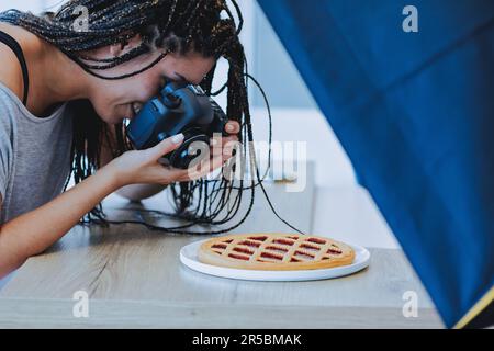 Eine junge Frau fotografiert leidenschaftlich eine Flittchen und nimmt ihren billigen kreativen Job an Stockfoto