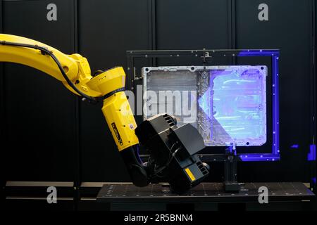 Ingenieur, der mit dem 3D-Roboterarm arbeitet, misst das Kfz-Teil in Smart Factory, Industry Stockfoto