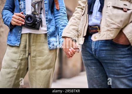 Nahaufnahme eines unerkennbaren erwachsenen Ehepaars, das sich im Freien an den Händen hält. Stockfoto