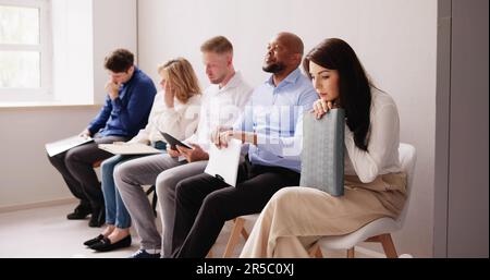 Die Menschen werden immer beim Sitzen auf Stuhl warten auf Job Interview im Büro langweilen Stockfoto