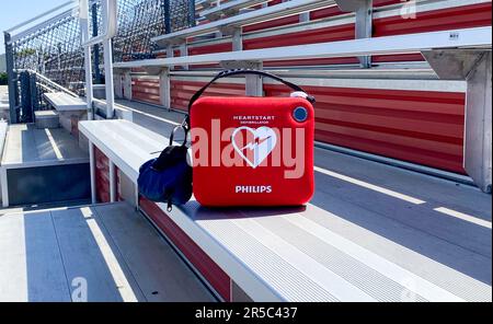 West Islip, New York, USA - 17. Mai 2023: Ein lebensrettender AED-Difibrillator in der Tribüne zum Schutz von Sportlern, Trainern und Fans. Stockfoto