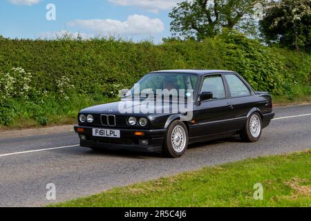 1988 schwarzer BMW 325I SE Oldtimer, frühere Motoren auf dem Weg zur Capesthorne Hall Vintage Collectors Car Show in Cheshire, Großbritannien Stockfoto