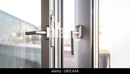 PVC- und Metallfenster-Nahaufnahme, Aluminium-Türfenster grau silberner Rahmen, Stockfoto