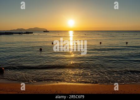 Schöner Sonnenuntergang oder Sonnenaufgang am Strand. Stockfoto