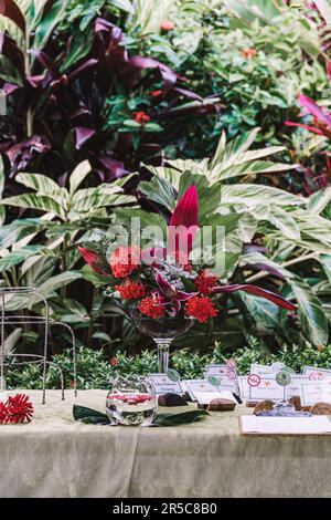 Dieses Bild zeigt einen atemberaubenden Hochzeitsempfang, geschmückt mit einer Fülle von bunten Blumen und üppigem Grün Stockfoto