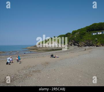 Ein paar Leute genießen eine friedliche entspannende Zeit an einem ruhigen, nicht überfüllten kleinen Strand Stockfoto