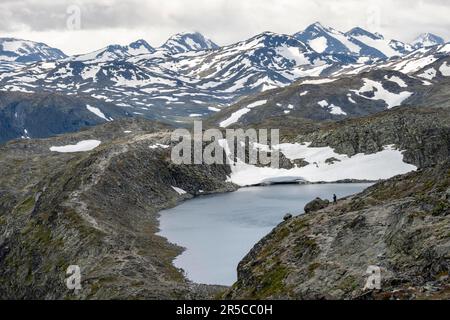 Schneebedeckte Berggipfel und Bjornboltjonne-See, Besseggen-Wanderung, Ridge Walk, Jotunheimen-Nationalpark, Vaga, Innlandet, Norwegen Stockfoto