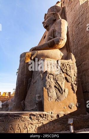 Blick aus dem niedrigen Winkel auf die Statue des Pharao Ramses II. Vor dem Pylon des Tempelkomplexes von Luxor in Luxor, Ägypten Stockfoto
