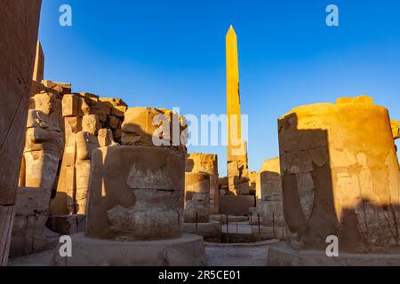 Ansicht des beschädigten Obelisken von Hatschepdut in der Mitte der alten Ruinen Hypostyle Halle und Statue des pharao in Karnak Temple Complex, Luxor, Oberägypten Stockfoto