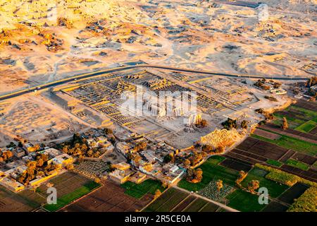 Luftaufnahme der Tempel von Ramesseum für Ramses II in der Nekropole Theban im Tal der Könige mit dem Dorf und kultiviertem Land, Luxor, Oberägypten Stockfoto