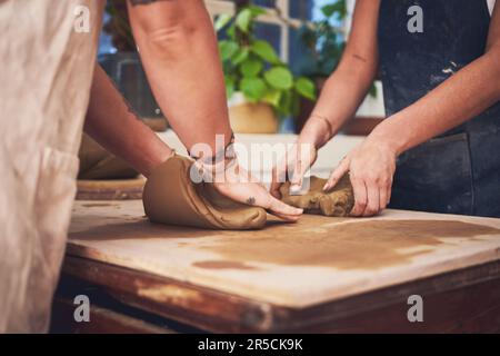 Das Leben gab dir Hände, um schöne Dinge zu erschaffen. Zwei unerkennbare Frauen kneten Ton in einem Töpferstudio. Stockfoto