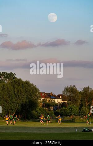 London, Großbritannien. 2. Juni 2023 UK Weather – Vor dem morgigen Strawberry Moon erhebt Sich Auf einem Spielfeld in der Nähe des Wembley-Stadions im Nordwesten Londons ein um 97,5 % schwindender Gibbous-Mond hinter einem gälischen Fußballspiel. Der Vollmond im Juni ist nach dem Almanach des Old Farmer so benannt, dass er das Signal für die indianischen Algonquin-Stämme war, wilde Erdbeeren zu ernten. Manchester City spielt Manchester United im FA-Cup-Finale morgen Nachmittag, und wenn sie gewinnen, feiern sie das in der Regel mit dem Song „Blue Moon“. Kredit: Stephen Chung / Alamy Live News Stockfoto