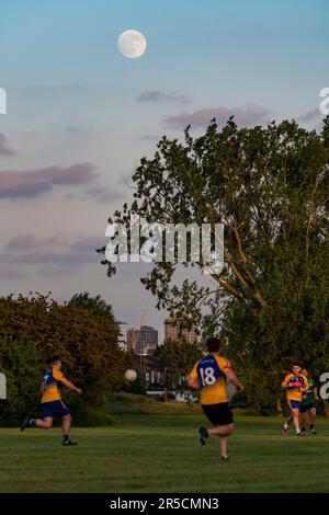 London, Großbritannien. 2. Juni 2023 UK Weather – Vor dem morgigen Strawberry Moon erhebt Sich Auf einem Spielfeld in der Nähe des Wembley-Stadions im Nordwesten Londons ein um 97,5 % schwindender Gibbous-Mond hinter einem gälischen Fußballspiel. Der Vollmond im Juni ist nach dem Almanach des Old Farmer so benannt, dass er das Signal für die indianischen Algonquin-Stämme war, wilde Erdbeeren zu ernten. Manchester City spielt Manchester United im FA-Cup-Finale morgen Nachmittag, und wenn sie gewinnen, feiern sie das in der Regel mit dem Song „Blue Moon“. Kredit: Stephen Chung / Alamy Live News Stockfoto