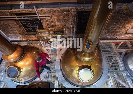 Ein Brennerarbeiter führt in der Holyrood Whisky-Brennerei Edinburgh verschiedene Aufgaben im Zusammenhang mit der Herstellung von Single Malt Whisky aus; Stockfoto