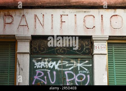 Außenansicht einer ehemaligen Bäckerei in einer venezianischen Gasse mit verwittertem Marmorschild, Graffiti und geschlossenen Fensterläden, Venedig, Veneto, Italien Stockfoto