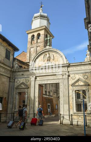 Eine kleine Gruppe von Touristen mit Trolleys, die im Sommer auf dem Kirchhof der Scuola Grande di San Giovanni Evangelista in Venedig, Venetien, Italien ankommen Stockfoto