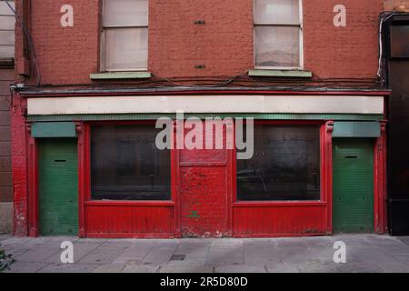 Heruntergekommenes altes Gebäude mit abblätternder Farbe und leerstehendem Shutterladen Stockfoto