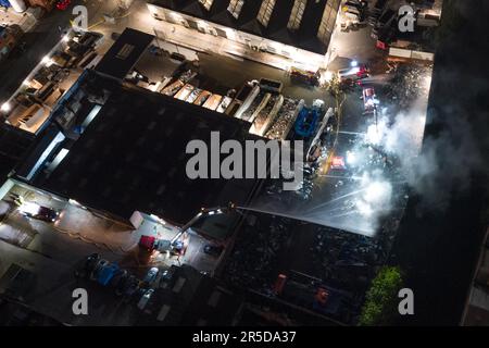 Cheston Road, Aston, Birmingham, 3. Juni 2023 - Luftaufnahmen eines Schrottplatzes in Aston Birmingham. Die Feuerwehr der West Midlands wurde gerufen, um einen Brand in einem Schrottplatz in der Cheston Road, Aston, in Birmingham zu melden. Anfangs wurden Crews aus Aston und ward End mobilisiert. Aufgrund der Anzahl der Anrufe und der Informationen der Anrufer wurden jedoch zusätzliche Feuerwehrleute für den Vorfall mobilisiert. Derzeit sind insgesamt zehn Feuerwehrleute (60 Feuerwehrleute) anwesend, die von einer hydraulischen Hubplattform und unserer Großraumpumpenanlage unterstützt werden. Der Vorfall betrifft eine große Menge an Schrott Stockfoto