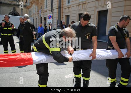 Salerno, Kampanien, Italien. 2. Juni 2023. Feuerwehr des Provinzkommandos von Salerno auf der Piazza Amendola, während sie die lange italienische Flagge früh am Morgen anlässlich der Feierlichkeiten zum „2. Juni des Tages der Italienischen Republik“ auf dem Gebäude des Polizeihauptquartiers anlässlich der Feierlichkeiten arrangieren (Bild: © Pasquale Senatore/Pacific Press via ZUMA Press Wire) NUR ZUR REDAKTIONELLEN VERWENDUNG! Nicht für den kommerziellen GEBRAUCH! Kredit: ZUMA Press, Inc./Alamy Live News Stockfoto